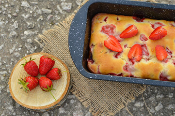 Delicious summer dessert strawberry pie, sweet homemade holiday cake decorated with mint leaves on a light concrete background.