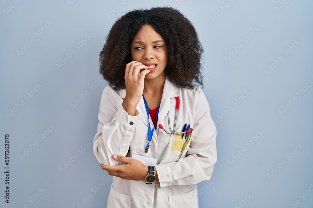 Poster Young african american woman wearing doctor uniform and stethoscope looking stressed and nervous with hands on mouth biting nails. anxiety problem.