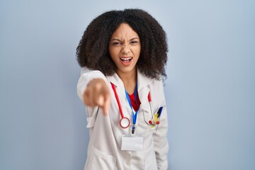 Young african american woman wearing doctor uniform and stethoscope pointing displeased and frustrated to the camera, angry and furious with you