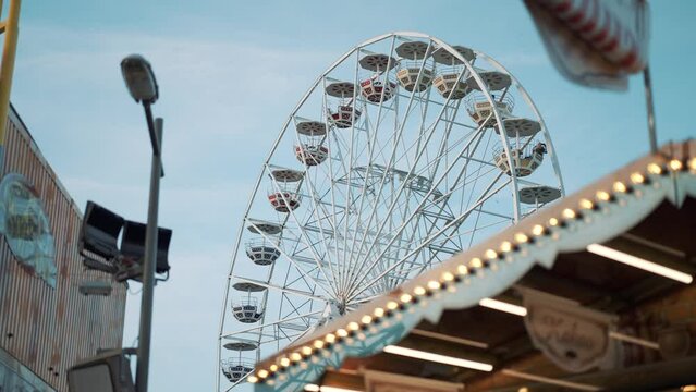 People having fun riding roller coaster ferris wheel at the amusement park on a sunny day