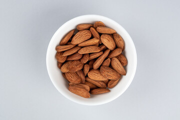 A bowl of almonds on the table. Scattering of almonds. Healthy snack with nuts.