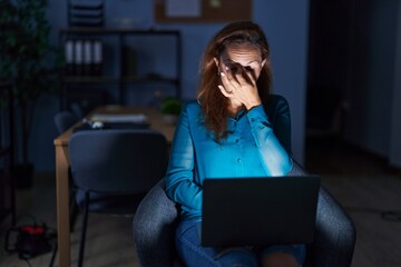 Brunette woman working at the office at night tired rubbing nose and eyes feeling fatigue and headache. stress and frustration concept.