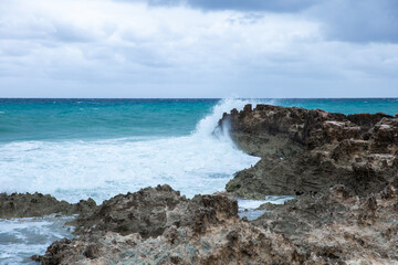 Fototapeta na wymiar Tropical storm in the Atlantic Ocean. Beautiful rocky shore with rolling waves. Hurricane in Caribbean Sea, Gulf of Mexico, Cancun.