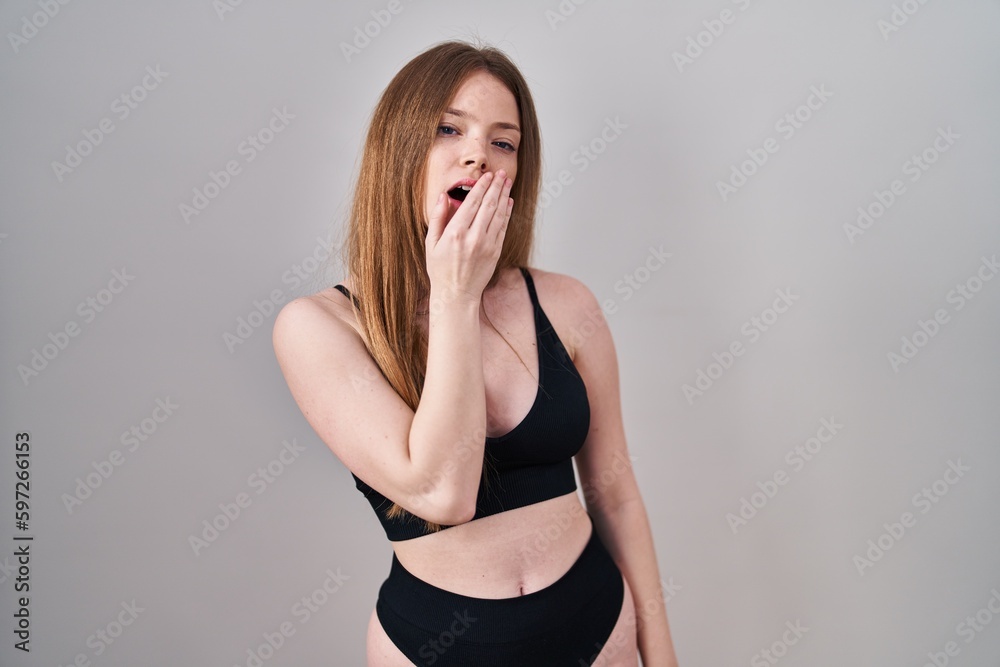 Canvas Prints young caucasian woman wearing lingerie bored yawning tired covering mouth with hand. restless and sl