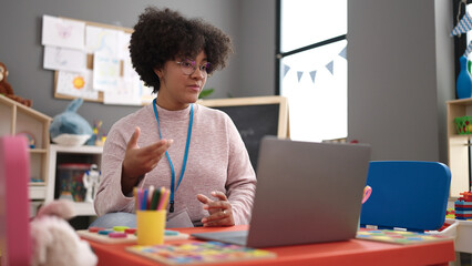 Young african american woman on a video call working as teacher at kindergarten