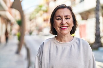 Middle age woman smiling confident standing at street