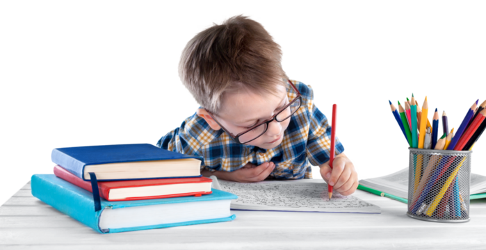 Happy child writing in a notebook in the classroom