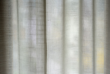 una bella tenda d'appartamento di colore bianco chiude una finestra