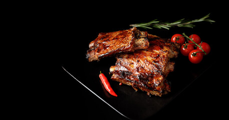 pork ribs with cherry tomatoes, lime, mushrooms and herbs on black background