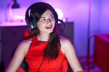 Young caucasian woman streamer smiling confident sitting on table at gaming room