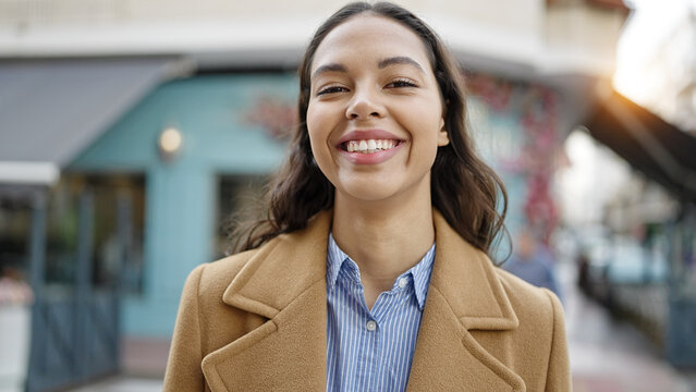 Young beautiful hispanic woman smiling confident at street