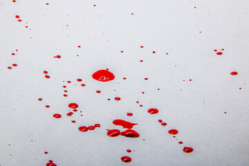 Red drops of paint on a white background	
