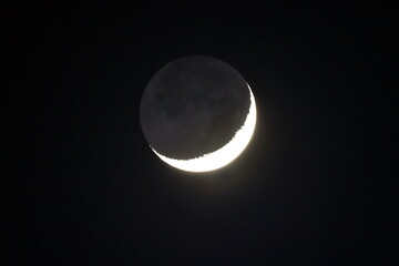 Bright light moon sickle at night.