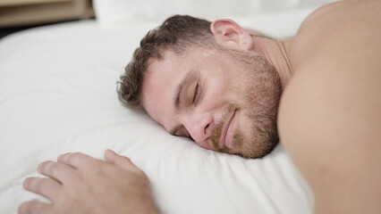 Young caucasian man lying on bed sleeping shirtless at bedroom