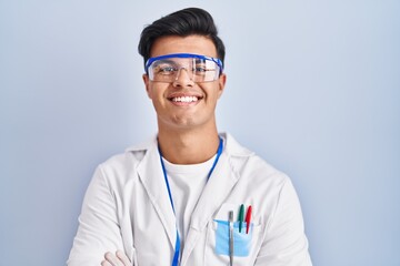 Hispanic man working as scientist happy face smiling with crossed arms looking at the camera. positive person.