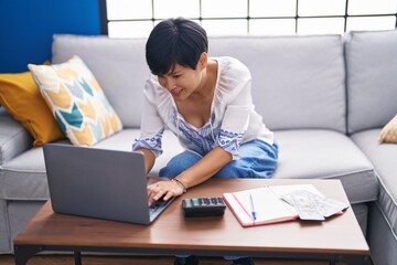 Middle age chinese woman using laptop accounting at home