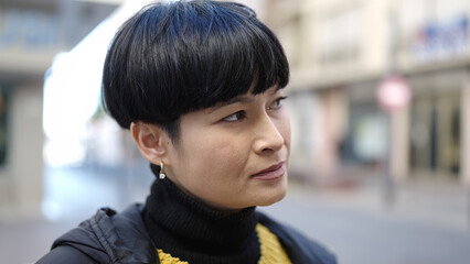 Obraz premium Young chinese woman looking to the side with serious expression at street