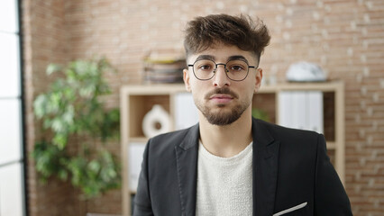 Young arab man business worker standing with relaxed expression at office