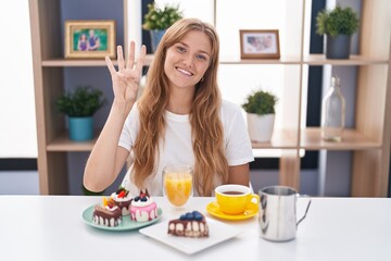 Obraz na płótnie Canvas Young caucasian woman eating pastries t for breakfast showing and pointing up with fingers number four while smiling confident and happy.