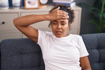 Obraz premium African american woman suffering for headache sitting on sofa at home