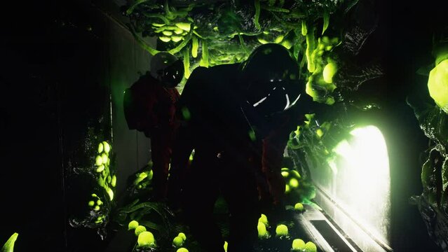 The astronauts inspect the airlock of their spacecraft captured by alien creatures. A creepy green alien invader with tentacles has taken over the spacecraft.