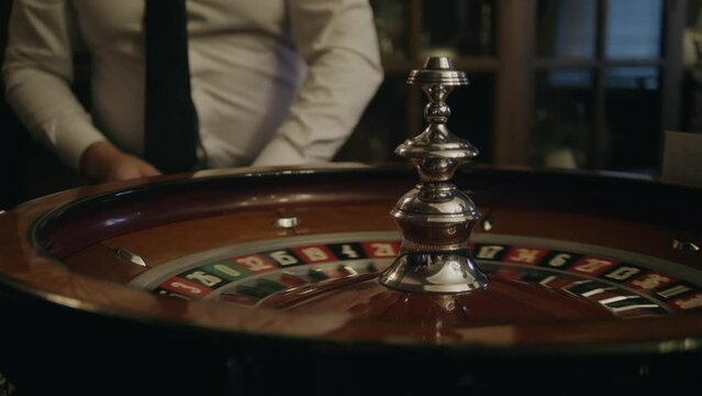 People play roulette in casino, game gold spinning roulette table close up, croupier dealer and roulette in a modern casino. 