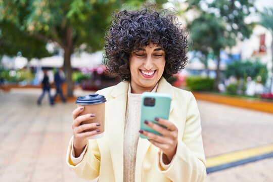 Young middle east woman excutive using smartphone drinking coffee at park