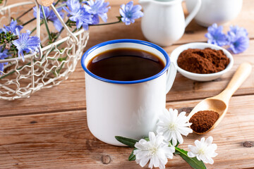Medicinal plant chicory. The roots of the plants are used as a substitute for coffee. Drink from chicory in a cup on the wooden table. Rustic style, selective focus