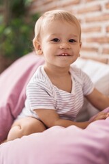 Fototapeta premium Adorable toddler smiling confident sitting on bed at bedroom