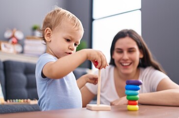Mother and son smiling confident playing at home