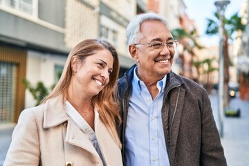 Middle age man and woman couple smiling confident standing together at street