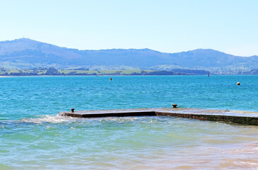 A breakwater near the beach with blue sea water and sky
