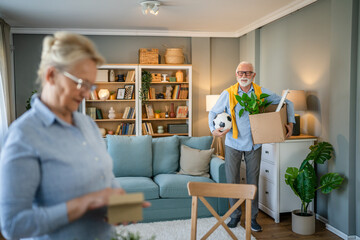 Senior couple man and woman husband wife pack or unpack boxes moving