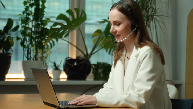 Woman, a call center and a computer with a headset, advising on telemarketing, customer service or office support. A happy female consultant talking about microphone setup on a desktop computer. 