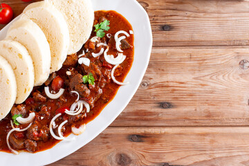 Traditional czech goulash with dumplings (knedliky) and beer on table. Place for text. Copy space
