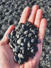 black pebbles on the beach in a hand in iceland