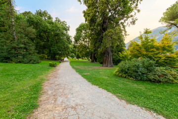 Fototapeta na wymiar A gravel path through the lakefront Martyrs of Liberty Park and treelined garden on the shores of Lake Como at the village of Bellagio, Italy.