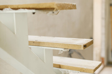 Unfinished wooden stairs to second floor in new building. Construction of house and home renovation concept