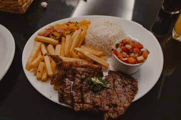 plate of food with steak, rice and potatoes
