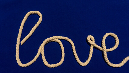 Fiber rope from which the word love is made on a blue background