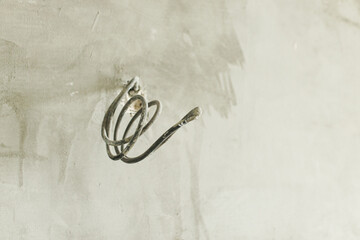 Unfinished room with electricity wires, plaster walls and dirt in new building. Construction of house and home renovation concept. Home improvement, cabling