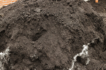 Black soil pile. Landscaping backyard and garden work concept. Clean soil for cultivation and...