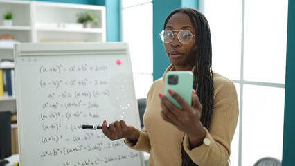 African woman recording teaching maths on magnetic board at library university