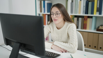 Fototapeta na wymiar Young beautiful hispanic woman student using computer studying at library university