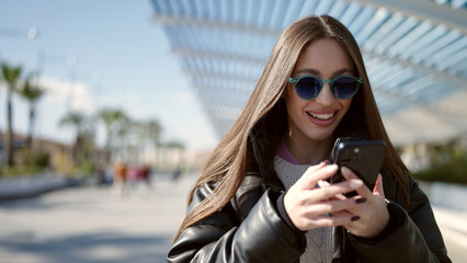 Young beautiful hispanic woman smiling confident using smartphone at park