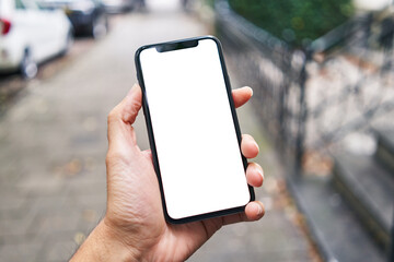 Man holding smartphone showing white blank screen at street