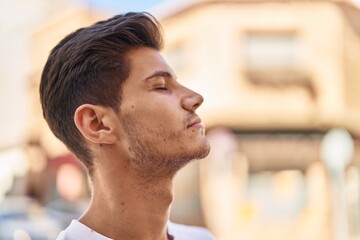 Young hispanic man breathing with closed eyes at park