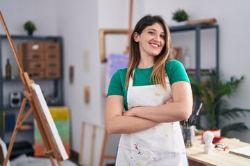 Young brunette woman at art studio happy face smiling with crossed arms looking at the camera. positive person.