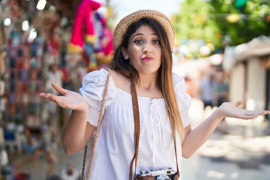 Young brunette woman on summer vacation shouting and screaming loud to side with hand on mouth. communication concept.