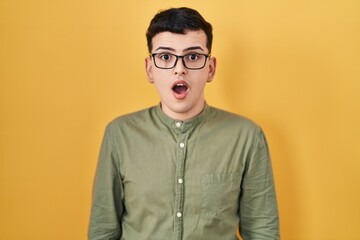 Non binary person standing over yellow background afraid and shocked with surprise expression, fear and excited face.